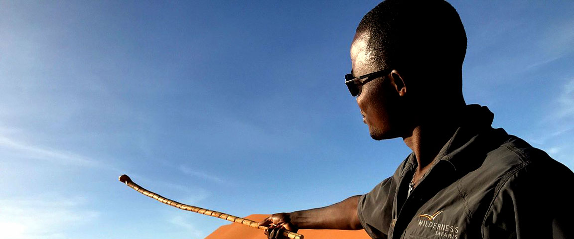 Guided from Wilderness Safaris pointing towards the red dunes of Sossusvlei in teh Namib Desert